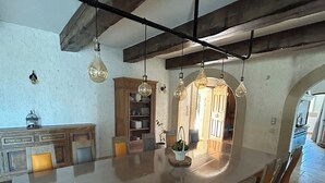 A spacious kitchen with a large island, wooden cabinets, and hanging light fixtures. - House at the foot of the Luberon with swimming pool 5 minutes from the village of Lourmarin, (Puyvert)