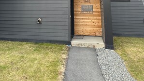 A modern building with a dark exterior, multiple windows, and a wooden entrance. - Bootlegger’s Nest
 (Anchorage)