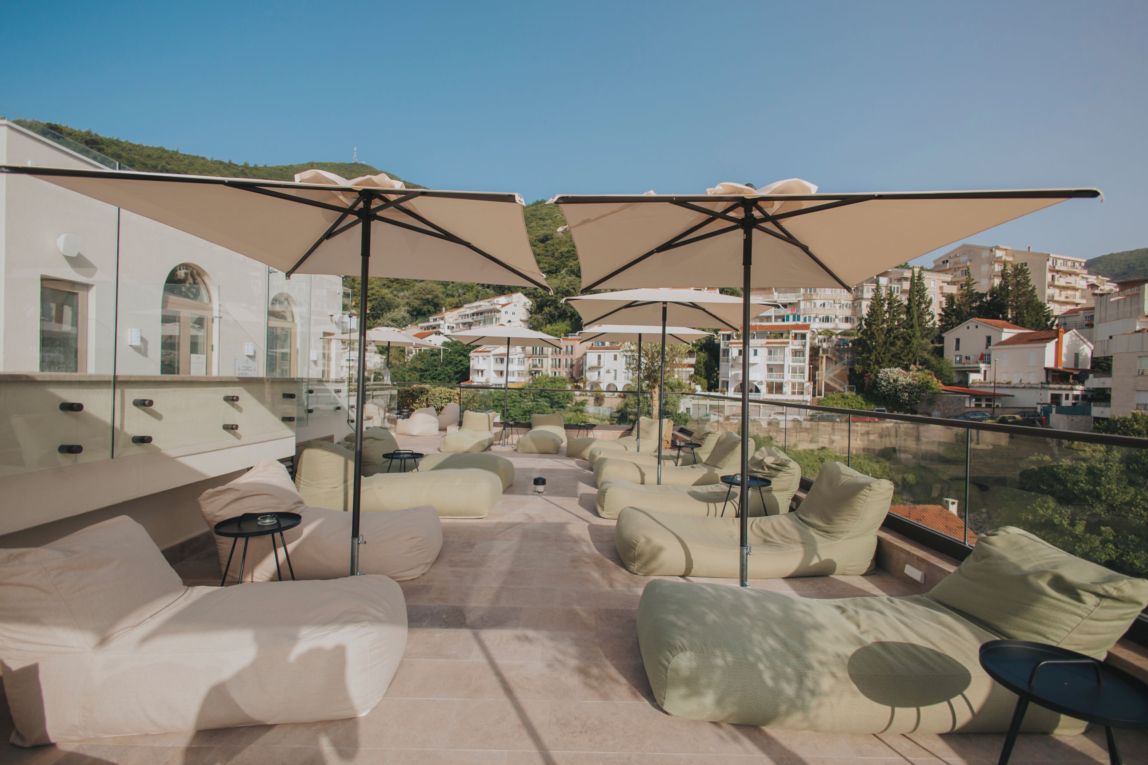 Una piscina al aire libre de temporada, sombrillas, tumbonas