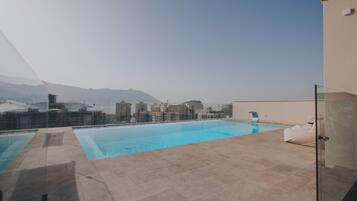 Una piscina al aire libre de temporada, sombrillas