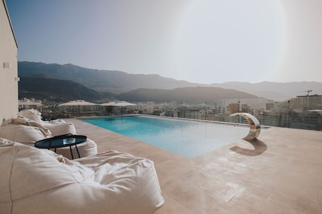 Una piscina al aire libre de temporada, sombrillas