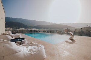 Una piscina al aire libre de temporada, sombrillas, tumbonas