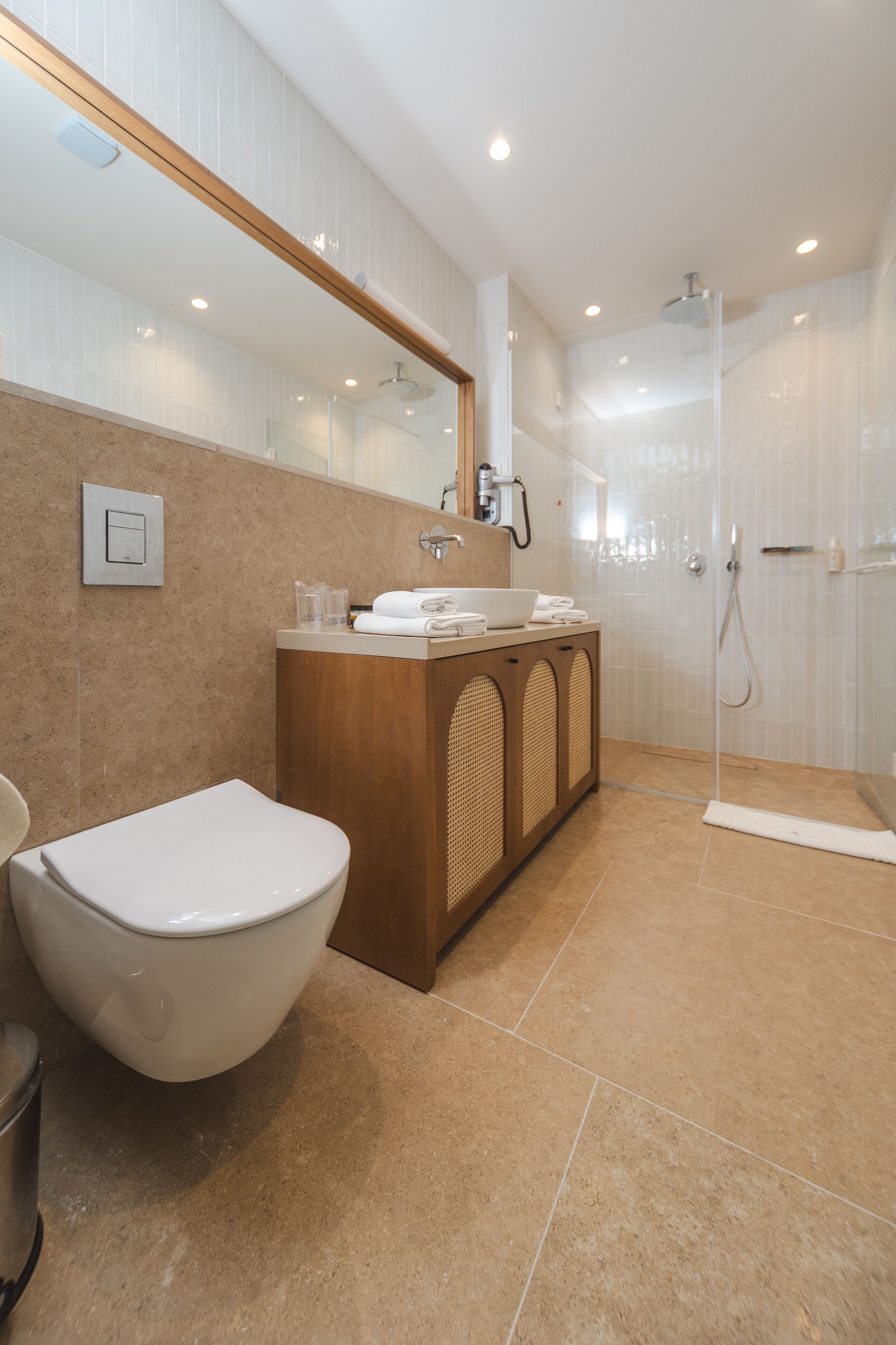 A modern bathroom with a toilet, sink, and shower.