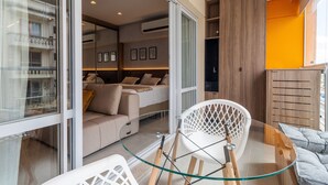 Ein modernes Interieur mit einem Glastisch, einer Couch und einem Holzkasten.