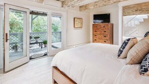 Un dormitorio con una cama grande, un aparador de madera y una televisión en la pared.