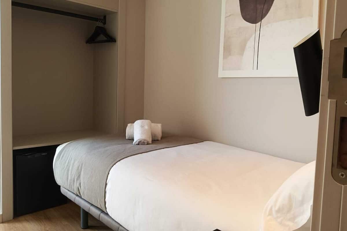 Un dormitorio con cama, armario y una toalla en el suelo.