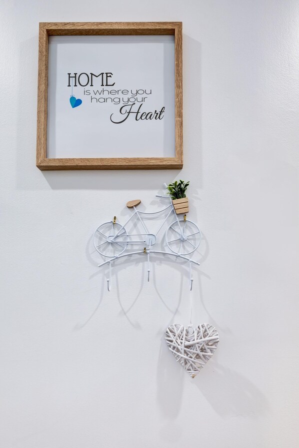 A framed quote on a wall, a white bicycle decoration, and a small potted plant. - All-Inclusive Furnished Large 2BR Apartment in Rosemont (Montréal)