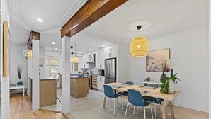 A modern kitchen with white cabinets, stainless steel appliances, and a wooden island. - All-Inclusive Furnished Large 2BR Apartment in Rosemont (Montréal)