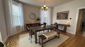 A dining area with a wooden table, benches, and a chandelier.