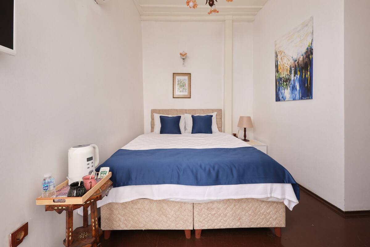 A bedroom with a bed, bedside table, and a nightstand.