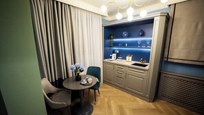 Uma sala de jantar moderna com uma mesa redonda, duas cadeiras, uma estante azul com objetos decorativos e um lustre.