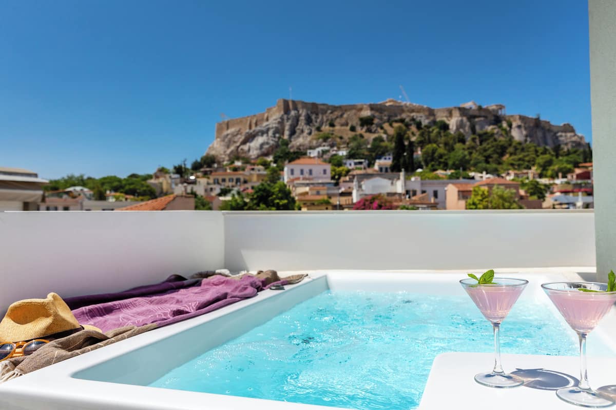 Une piscine sur le toit offrant une vue sur une forteresse historique perchée sur une colline.