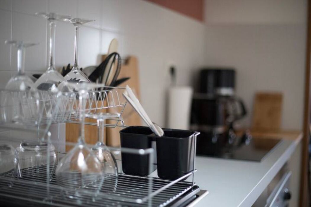 Une cuisine équipée d’une machine à café, d’un bloc à couteaux et d’un porte-verres à vin.