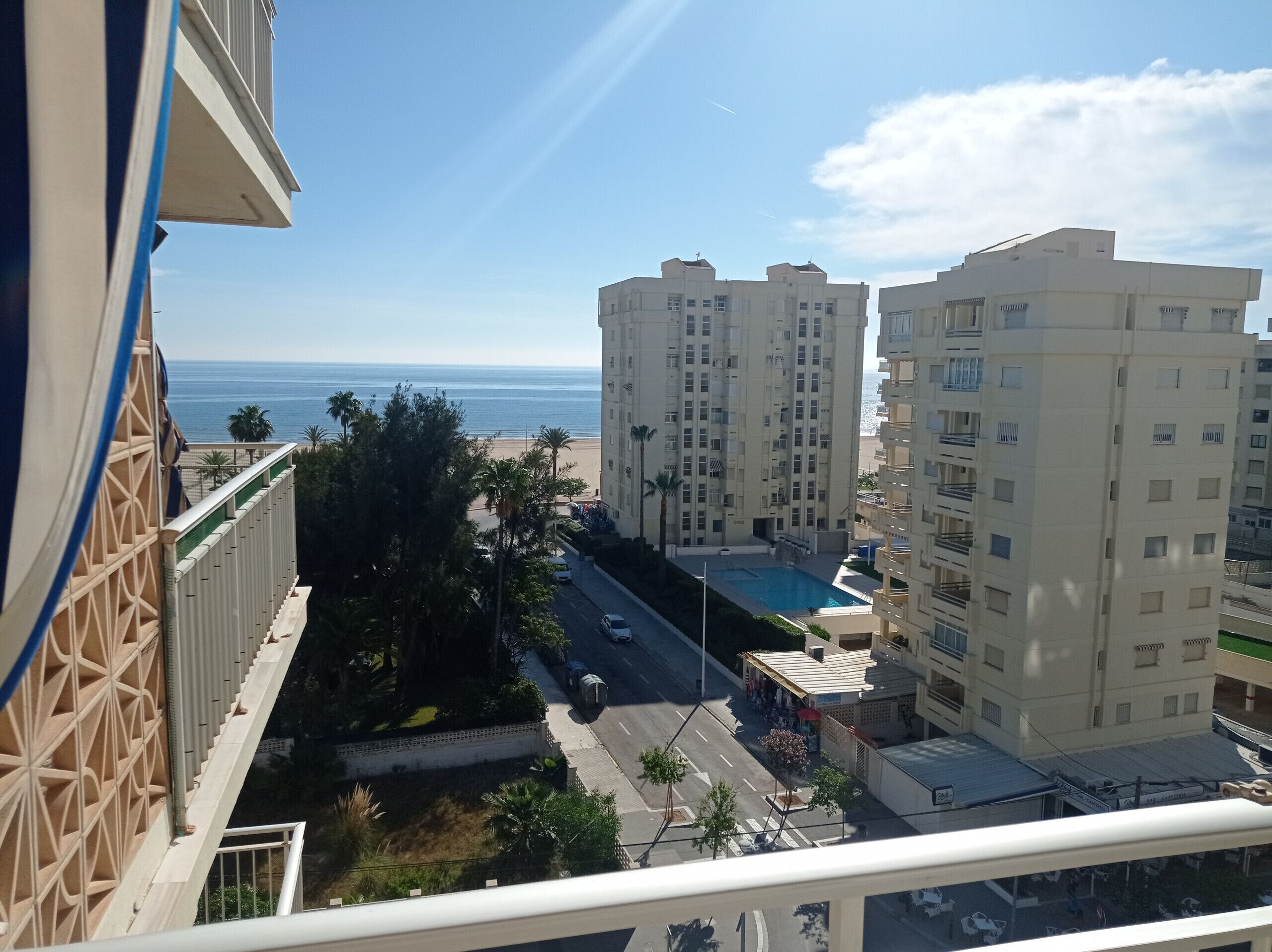 A high-rise building with a pool and a view of the beach.