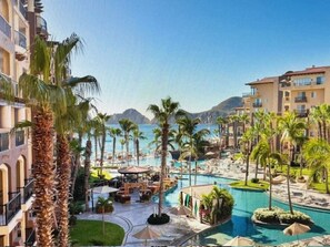 A resort with a central pool, palm trees, and a mountainous backdrop. - Villa del Arco, CABO San Lucas, 1 Bed, 2 Bath, 09/18-09/25/24, inquire less days (Cabo San Lucas)