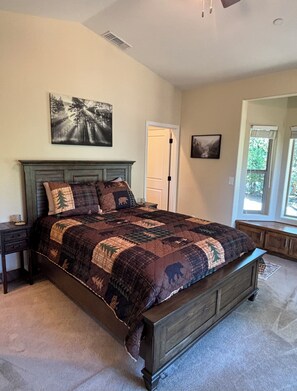 A bedroom with a large bed, a nightstand, a dresser, and a window with curtains. - Pollock Pines - Family get away, 2 miles from Sly Park lake - Near Apple Hill

 (Pollock Pines)