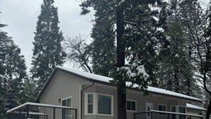 A single-story house with a covered porch, a garage, and a snow-covered yard. - Pollock Pines - Family get away, 2 miles from Sly Park lake - Near Apple Hill

 (Pollock Pines)