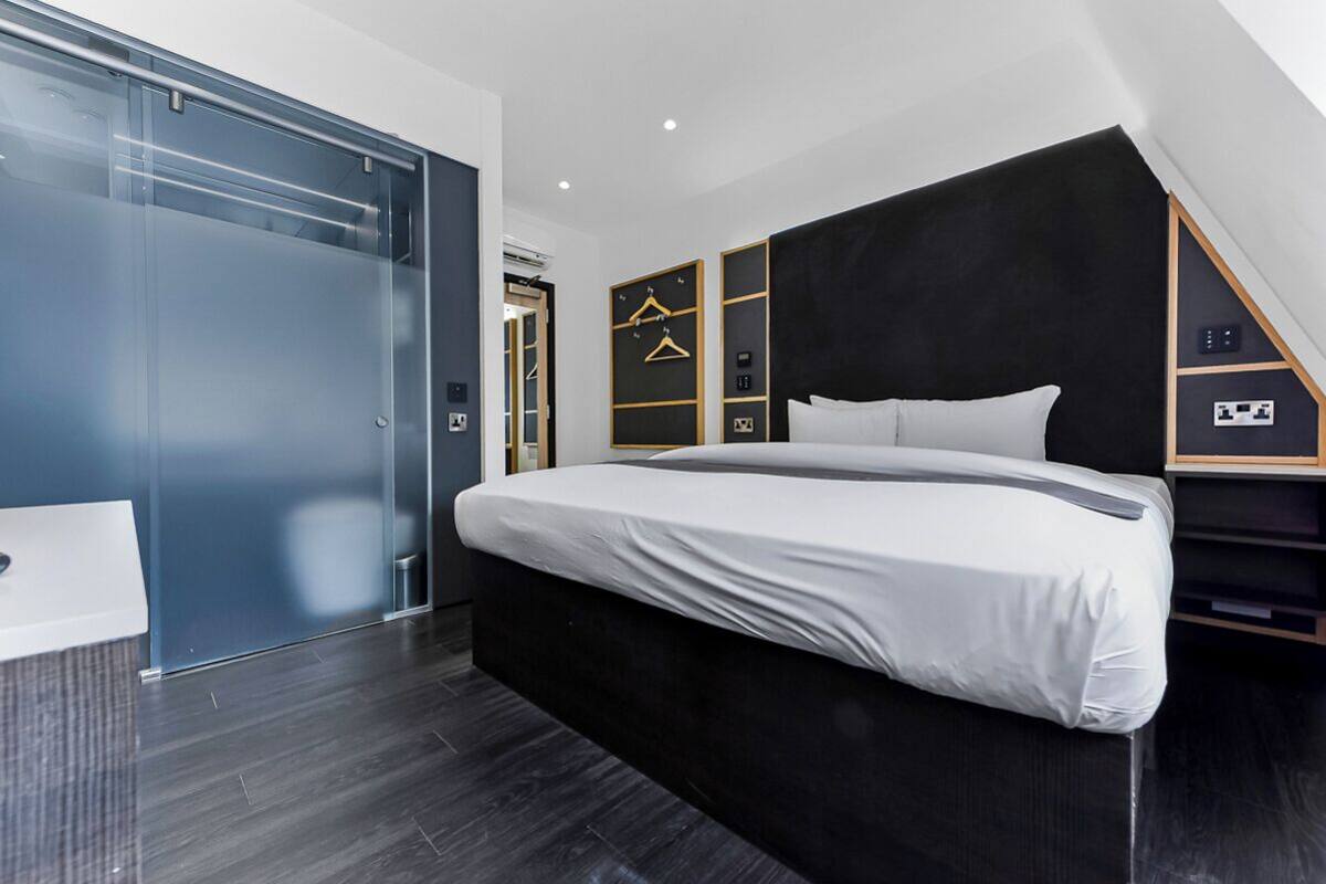 Een moderne slaapkamer met een groot bed, een kledingkast en een inbouwkast.