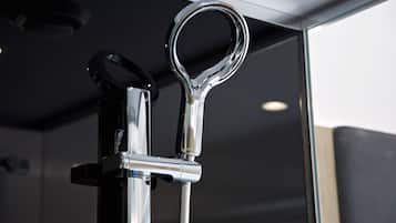 A metallic handle attached to a vertical structure, likely part of a door or window mechanism.