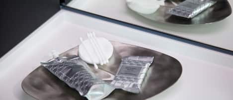 A tray with a toothbrush, toothpaste, and a packet of natural soap.