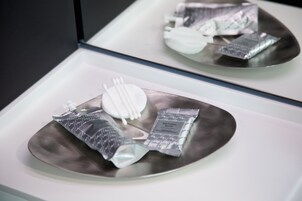 A tray with a toothbrush, toothpaste, and a packet of natural soap.