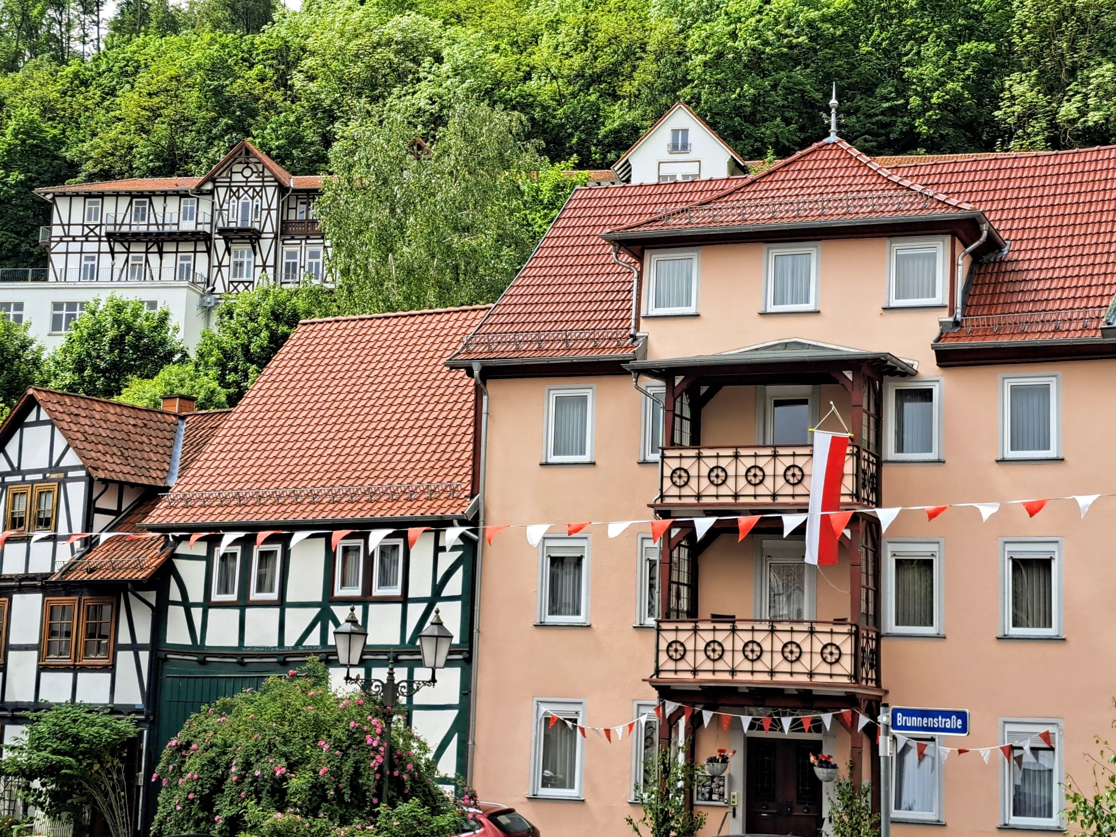 Ein traditionelles europäisches Gebäude mit Balkon, Straßenschild und Wimpel.