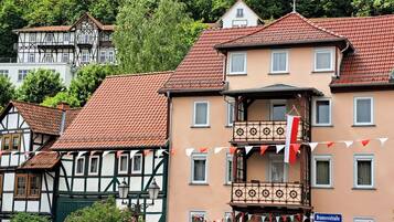 Ein traditionelles europäisches Gebäude mit Balkon, Straßenschild und Wimpel.
