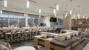 A modern bar area with seating and a large TV screen. - SpringHill Suites by Marriott Tampa Downtown (Tampa)