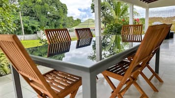 Relax in a serene outdoor seating area surrounded by lush greenery and trees.
