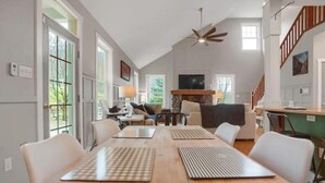 A spacious dining area with a long wooden table, white chairs, and a ceiling fan. - Top of Lemont - Minutes to Downtown State College and Penn State (Lemont)