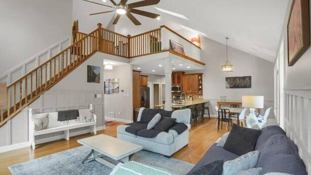 A spacious living area with a staircase leading to an upper level, a dining area, and a kitchen. - Top of Lemont - Minutes to Downtown State College and Penn State (Lemont)