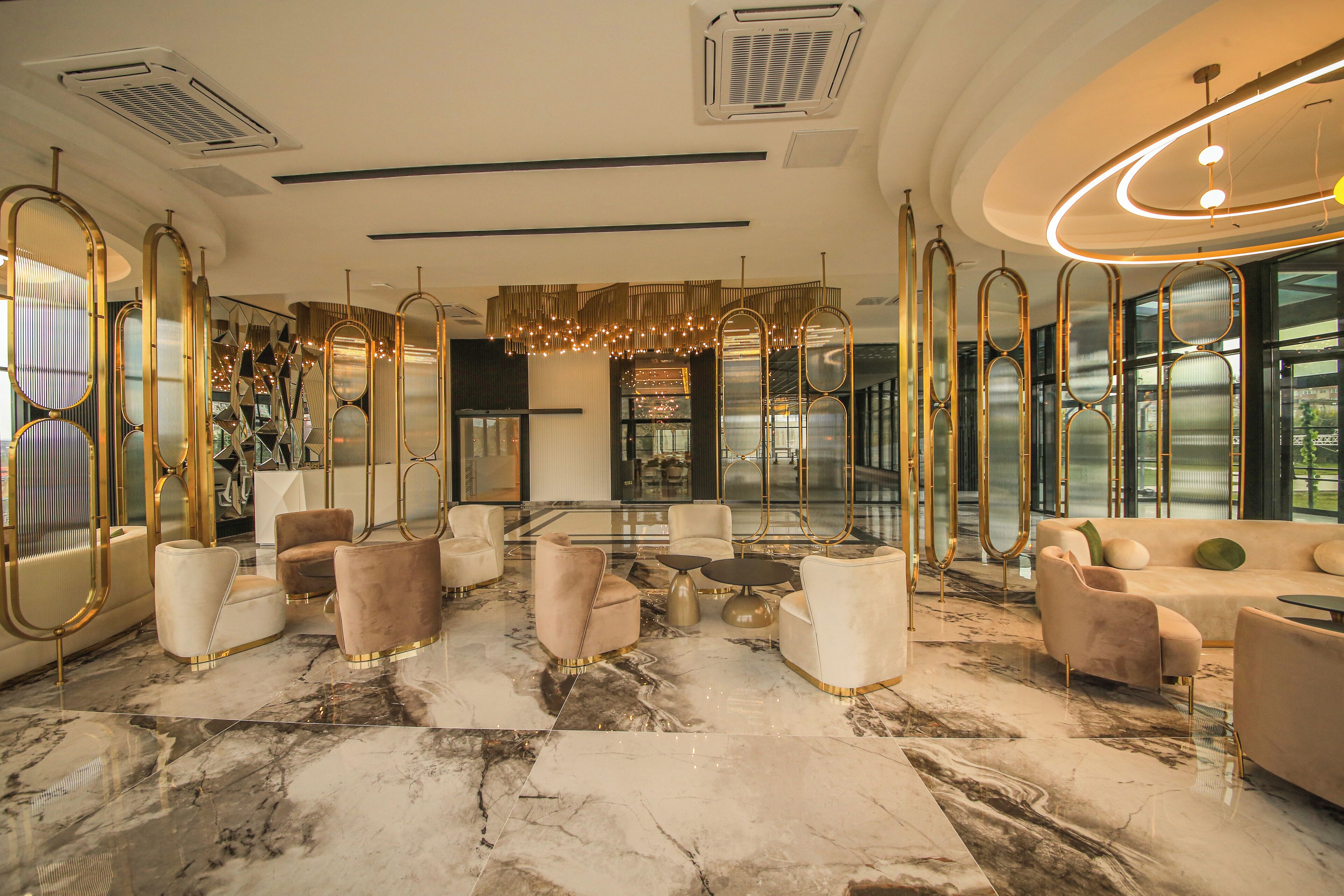 Eine luxuriöse Lobby mit Marmorböden, stilvollem Mobiliar und großen Fenstern mit Blick ins Freie.