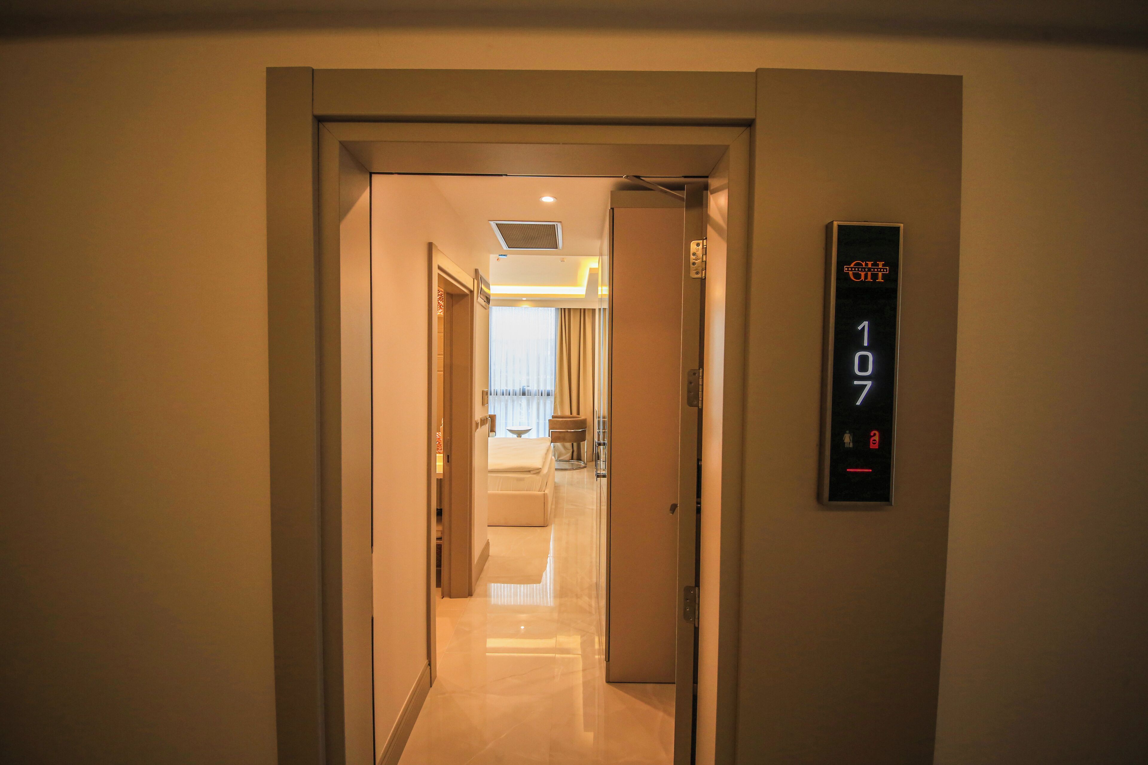 A hotel hallway with a digital elevator display showing the floor number 107.