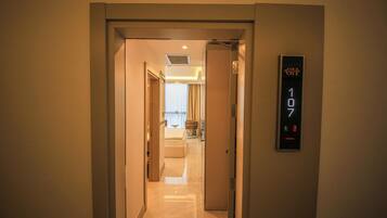 A hotel hallway with a digital elevator display showing the floor number 107.