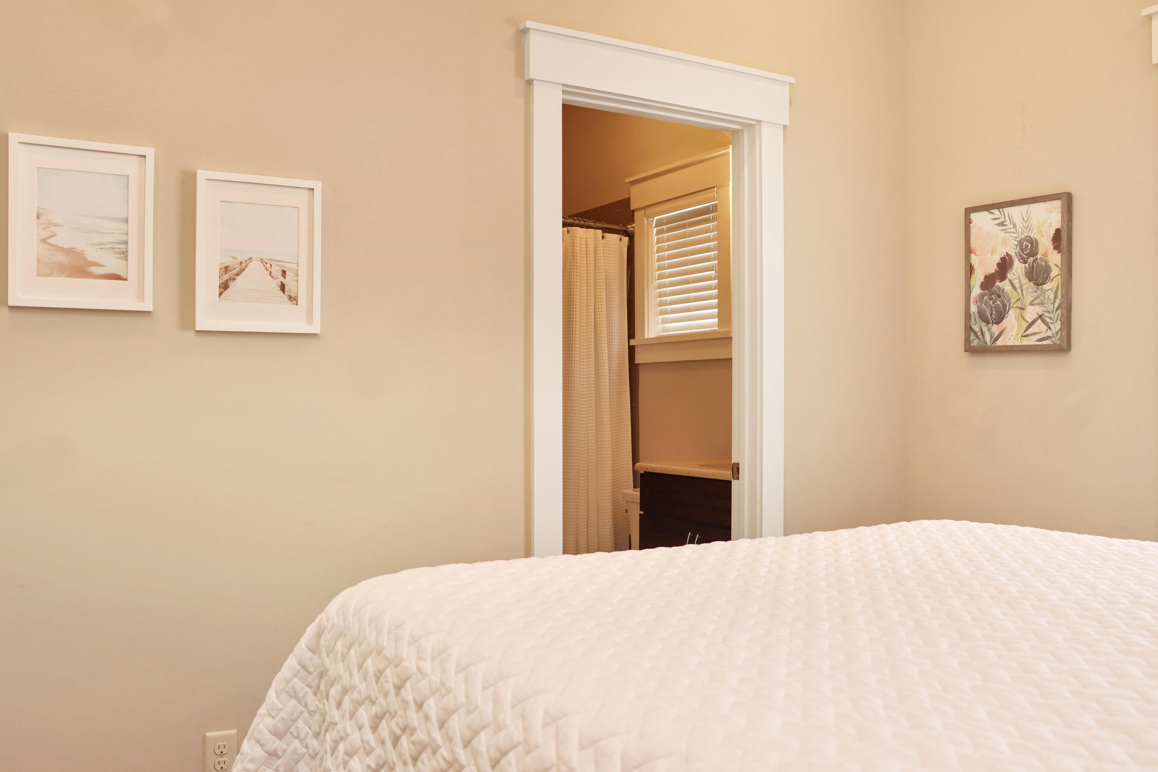 A bedroom with a bed, a closet, and two framed pictures on the wall.