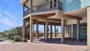 A two-story house with a balcony and a covered patio area. - The Blue Turtle (Port St. Joe)