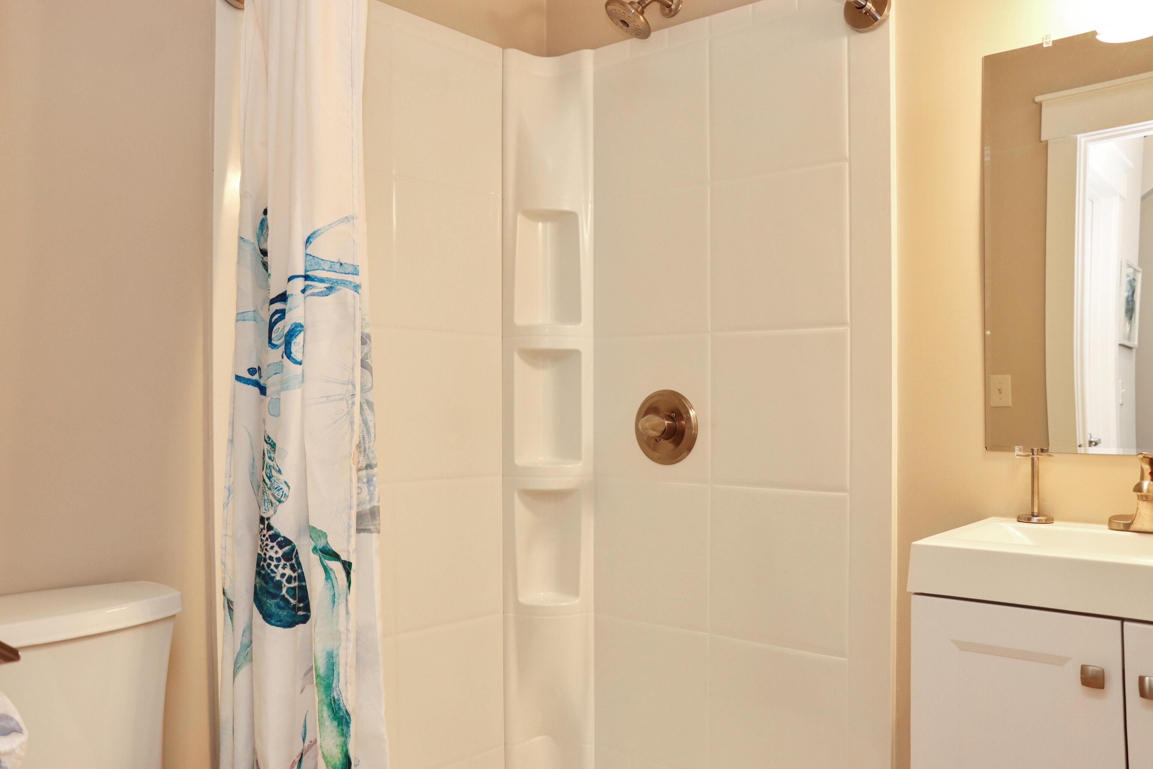 A bathroom with a shower, toilet, and sink.