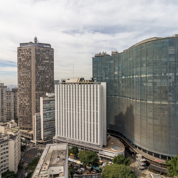 A high-rise building with a curved glass facade, surrounded by other tall buildings. - Bento 101 in S o Paulo (São Paulo)