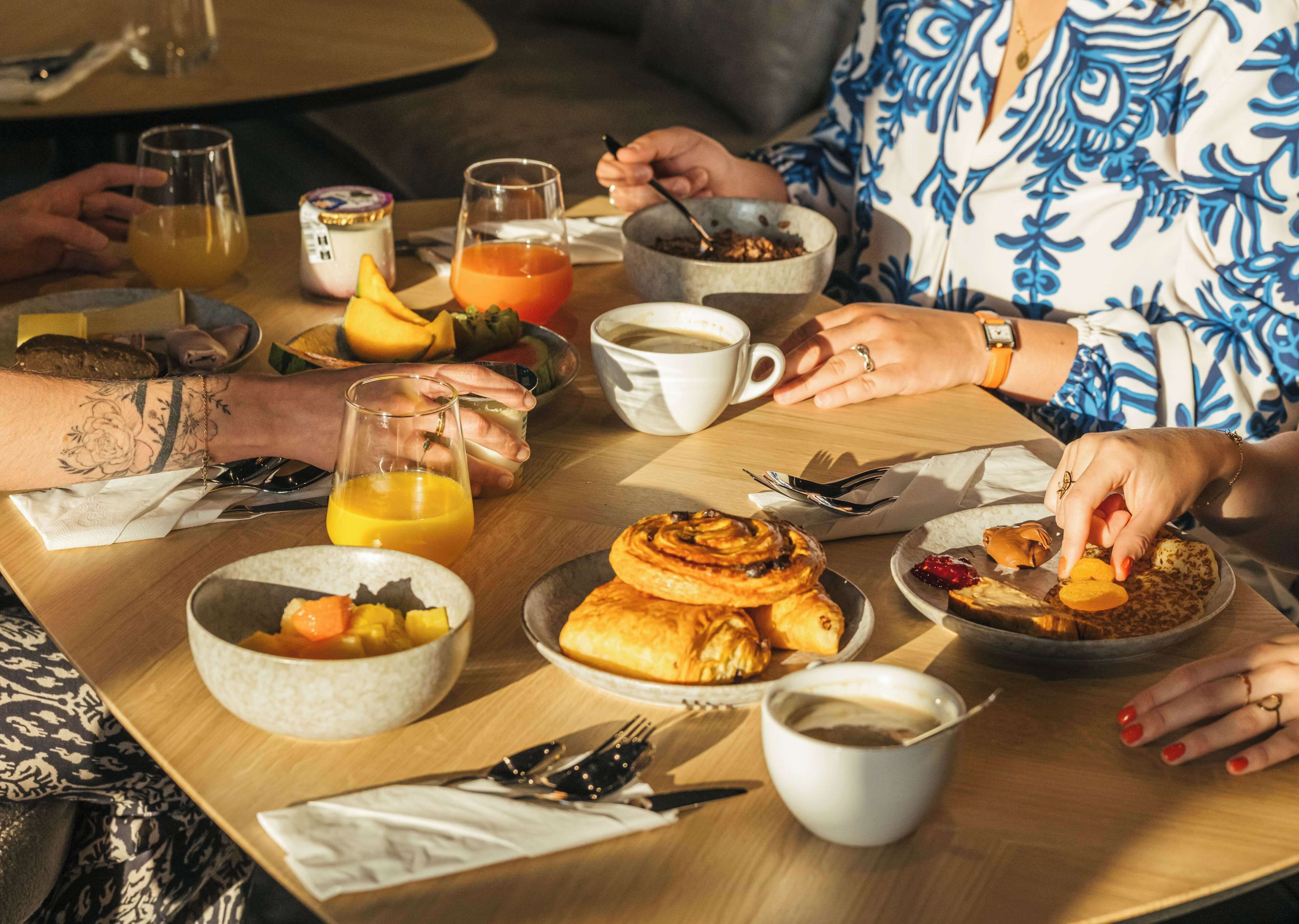 A breakfast setting with various food items and drinks on a table.