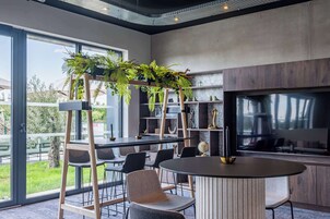 A modern kitchen with a large window, a round dining table, and a built-in TV.