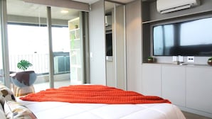 A modern hotel room with a large bed, a television, and a sliding glass door leading to a balcony. - Melo 1701 in S o Paulo (São Paulo)