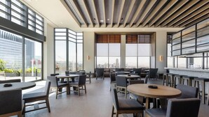 Un intérieur moderne avec de grandes fenêtres, de nombreux espaces de détente et une vue sur la ville.