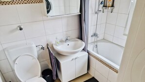 Une salle de bain avec des toilettes, un lavabo et une baignoire.