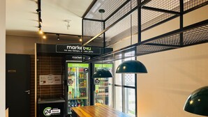 A modern interior with a wooden bar, seating, and a vending machine labeled 'market4u'. - Studio Sao Paulo PUC Allianz Park 401WB (São Paulo)