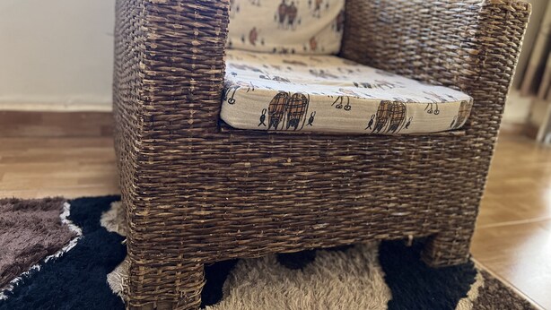 Une chaise en osier avec un coussin à motifs.