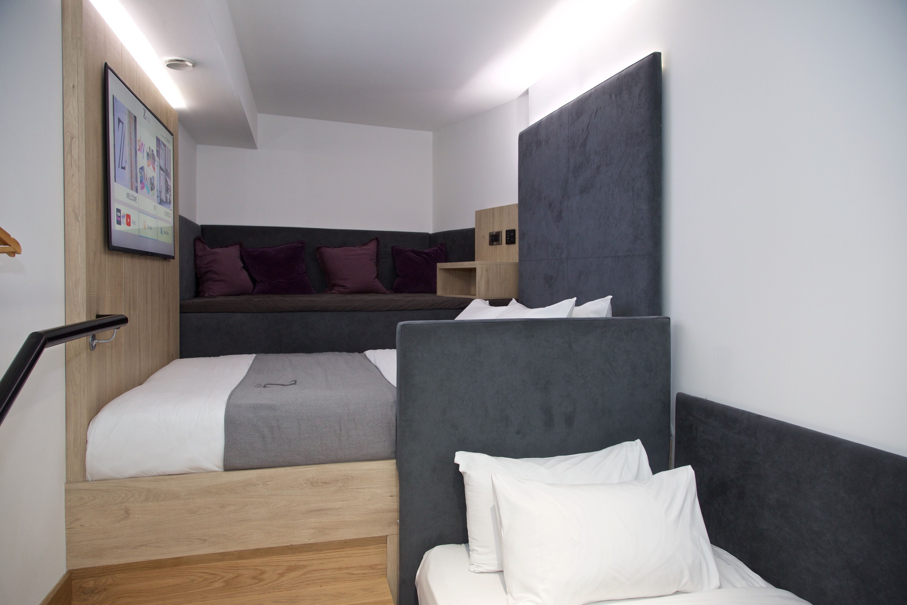 Una habitación de hotel moderna con cama, escritorio y un pequeño rincón de descanso.