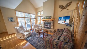 A spacious living room with a fireplace, large windows, and a cozy seating area. - Northstar 1961 (Keystone)