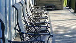 A row of outdoor seating chairs on a wooden deck, a hot tub, and a building with vertical siding. - The Pond View House - quiet country getaway w/ hot tub
 (Leesburg)