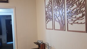 Comedor con mesa, sillas y paneles decorativos en la pared.