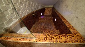 A bathroom with mosaic tile flooring and a glass shower enclosure. - CASTEL TRANSILVANIA (Baia Mare)